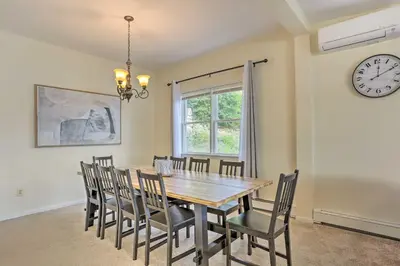 a dining room with a wooden table and chairs at Spacious Lakefront House With a Private Dock in Hopatcong