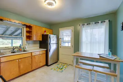 a kitchen with a stainless steel refrigerator and a window at Quaint Horseheads Home about 9 Mi to Elmira College in Horseheads