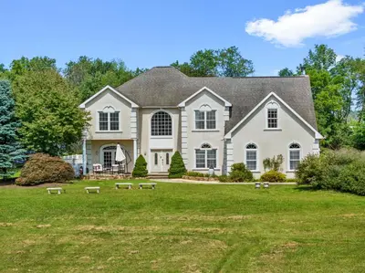 a large white house with a grass yard at 13-Acre Private Estate, Private Lake, Private Golf Range, Private Forest & Hiking Trails in Ross Corner