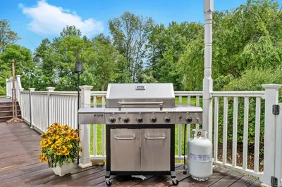 a grill on a deck with a fence at 13-Acre Private Estate, Private Lake, Private Golf Range, Private Forest & Hiking Trails in Ross Corner