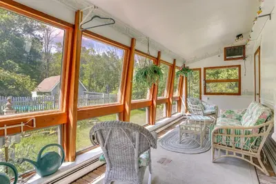 a living room with windows and chairs and a balcony at Sparrow Bush Retreat with Pool and Screened Porch in Sparrow Bush