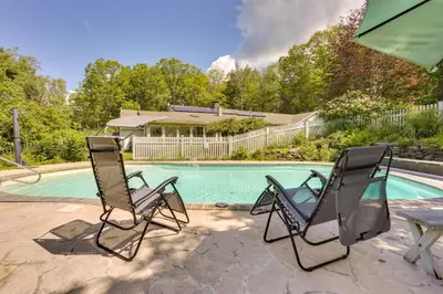 two chairs sitting next to a swimming pool at Sparrow Bush Retreat with Pool and Screened Porch in Sparrow Bush
