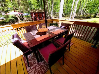 a wooden table and chairs on a deck at 3 bedroom Rental pet friendly, fireplace, hot tub, near ski resorts in Albrightsville