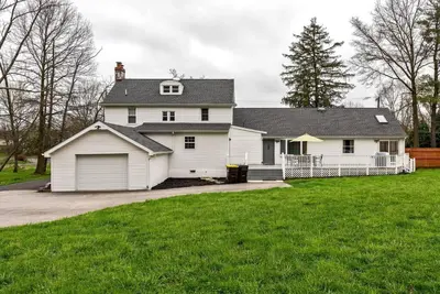 a white house with a garage and a grass yard at 5 Bdrm House (Sleeps 10) Horsham-Philadelphia in Horsham