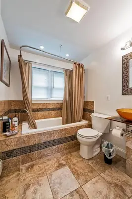 a bathroom with a toilet and a tub and a window at 5 Bdrm House (Sleeps 10) Horsham-Philadelphia in Horsham