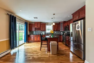 a kitchen with wooden cabinets and a table and a refrigerator at 5 Bdrm House (Sleeps 10) Horsham-Philadelphia in Horsham