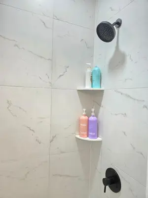 a bathroom with two soap bottles on shelves in a shower at Large Group Home NJ Close To NYC Train in Boonton