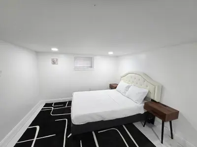a white bedroom with a bed and a rug at Large Group Home NJ Close To NYC Train in Boonton