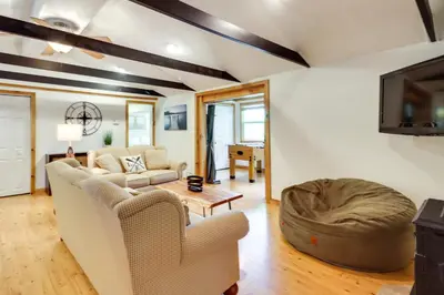 a living room with a couch and a table at Walk to Beaches Tree-Lined Pocono Lake Retreat! in Pocono Lake