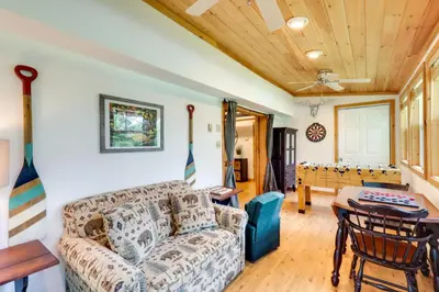 a living room with a couch and a table at Walk to Beaches Tree-Lined Pocono Lake Retreat! in Pocono Lake