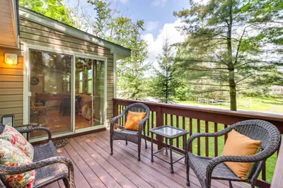 a porch with rocking chairs and a table at Walk to Beaches Tree-Lined Pocono Lake Retreat! in Pocono Lake
