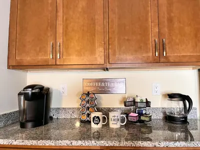a kitchen counter with wooden cabinets and coffee cups at Hidden Gem in Philadelphia