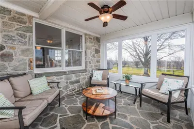 a living room with a stone wall at The Craftsman's Homestay in Gordonville