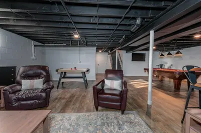 a living room with a pool table and leather chairs at The Craftsman's Homestay in Gordonville