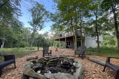 two chairs and a fire pit in front of a house at Evergreen Escape - Jim Thorpe Multi Ski Resort in Albrightsville