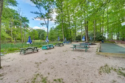 a group of picnic tables with umbrellas in a park at Near Big Boulder Mtn! Home with Fireplace and Games in Lake Harmony