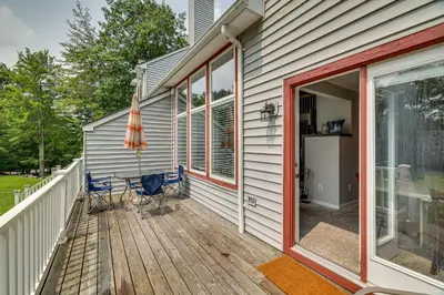 a deck with chairs and an umbrella on a house at Near Big Boulder Mtn! Home with Fireplace and Games in Lake Harmony