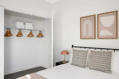 a white bedroom with a white bed and towels at Hoboken 2BR w Doorman Gym WD nr shuttle NYC-717 in Hoboken