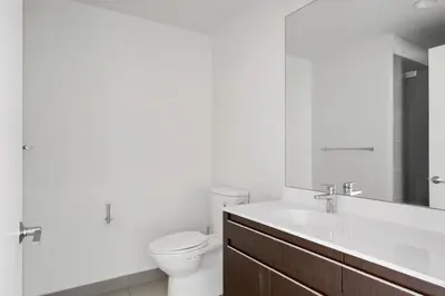a white bathroom with a toilet and a sink at Hoboken 2BR w Doorman Gym WD nr shuttle NYC-717 in Hoboken