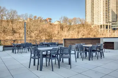 a row of tables and chairs on a patio at Hoboken 2BR w Doorman Gym WD nr shuttle NYC-717 in Hoboken