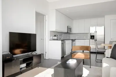 a living room with a kitchen with a table and a couch at Hoboken 2BR w Doorman Gym WD nr shuttle NYC-717 in Hoboken