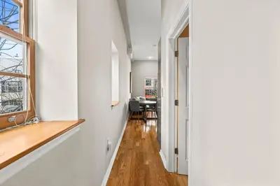 a hallway with white walls and a window and a table at Beautiful 1BD With Balcony Hosted By StayRafa - 2F in Philadelphia