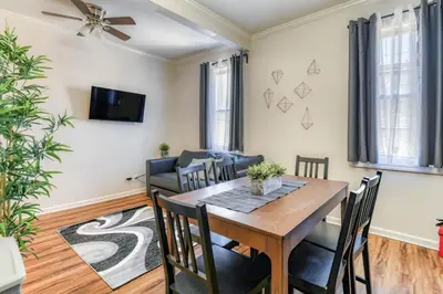 a dining room with a table and chairs and a couch at TWO Modern Apartment Minutes to NYC in Jersey City