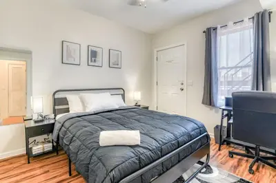 a bedroom with a bed and a desk and a window at TWO Modern Apartment Minutes to NYC in Jersey City