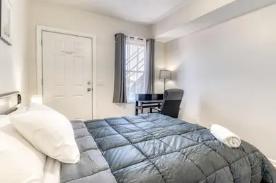 a bedroom with a bed and a chair and a window at TWO Modern Apartment Minutes to NYC in Jersey City