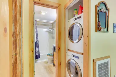 a bathroom with a washer and dryer next to a toilet at Pools and Ski Access Lackawaxen Cottage with Deck! in Lackawaxen