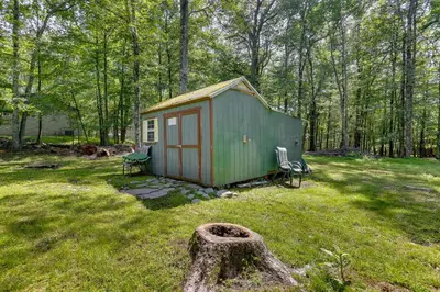 a green shed in the middle of a yard at Pools and Ski Access Lackawaxen Cottage with Deck! in Lackawaxen