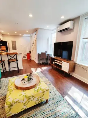 a living room with a couch and a tv and a table at Charming 1BDR In Central Rittenhouse Square With Patio Hosted by StayRafa in Philadelphia