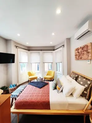 a bedroom with a large bed with two yellow chairs at Charming 1BDR In Central Rittenhouse Square With Patio Hosted by StayRafa in Philadelphia