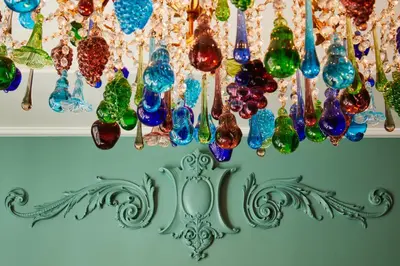 a bunch of glass vases hanging from a wall at The Fifth Avenue Hotel in New York