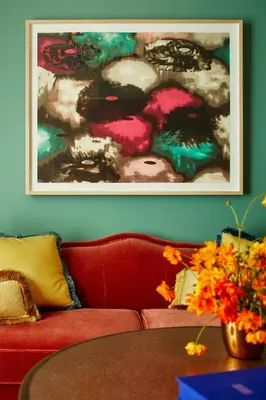 a living room with a red couch and a painting on the wall at The Fifth Avenue Hotel in New York