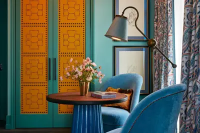 a room with blue chairs and a table with flowers at The Fifth Avenue Hotel in New York