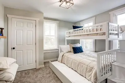a bedroom with a white bunk bed with blue pillows at Beautiful Farmhouse close to Lanc Hershey Etown in Mount Joy