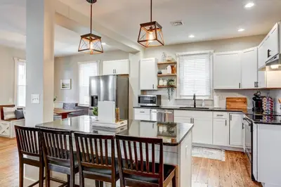 a kitchen with white cabinets and a table with chairs at Beautiful Farmhouse close to Lanc Hershey Etown in Mount Joy