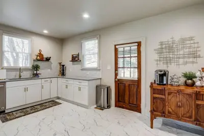 a large kitchen with white cabinets and a door at The Conservatory-20 min to Lanc in Mount Joy