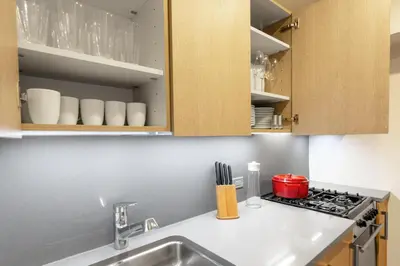 a kitchen with a sink and a stove at Chelsea 1BR w Balcony Doorman Gym NYC-135 in New York