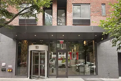 a building with a revolving door in front of it at Chelsea 1BR w Balcony Doorman Gym NYC-135 in New York