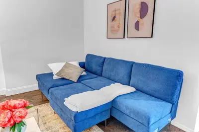 a blue couch in a living room with a vase of flowers at 2Bd Stylish Brooklyn Heights - Steps WaterFront in Brooklyn