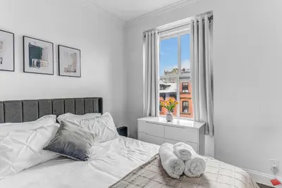 a white bedroom with a bed with towels on it at 2Bd Stylish Brooklyn Heights - Steps WaterFront in Brooklyn