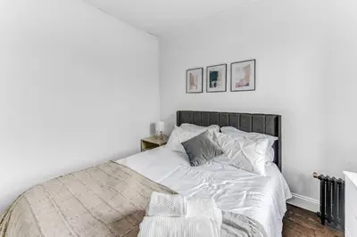 a bedroom with a bed with white sheets and pillows at 2Bd Stylish Brooklyn Heights - Steps WaterFront in Brooklyn