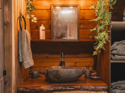 a bathroom with a stone sink in a cabin at Enchanting River- Water Front A-Frame Cabin in Yulan