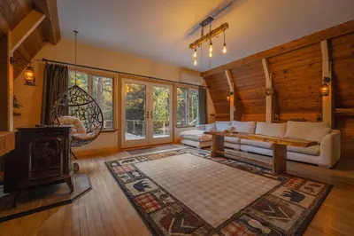 a living room with a couch and a fireplace at Enchanting River- Water Front A-Frame Cabin in Yulan