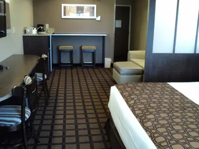 a hotel room with a bed and a table and chairs at Microtel Inn & Suites Mansfield PA in Mansfield