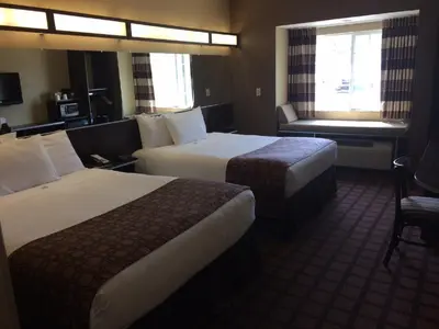 a hotel room with two beds and a window at Microtel Inn & Suites Mansfield PA in Mansfield