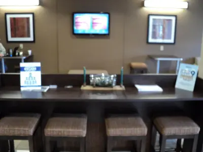 a bar in a restaurant with a table and stools at Microtel Inn & Suites Mansfield PA in Mansfield