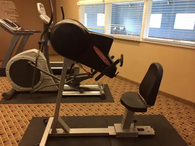 a gym with a chair and a treadmill at Microtel Inn & Suites Mansfield PA in Mansfield